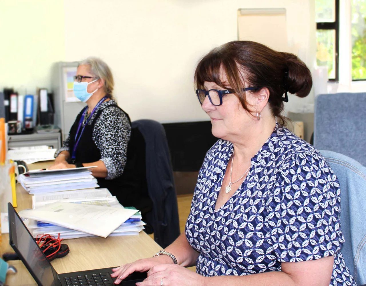 Two women sat at desks working on computers