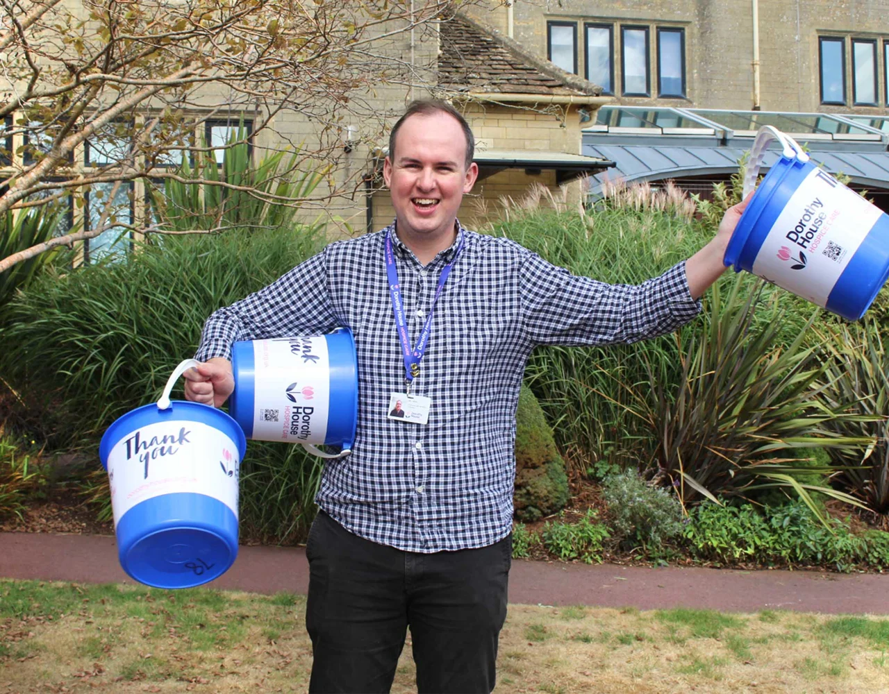 Man holding 3 fundraising buckets
