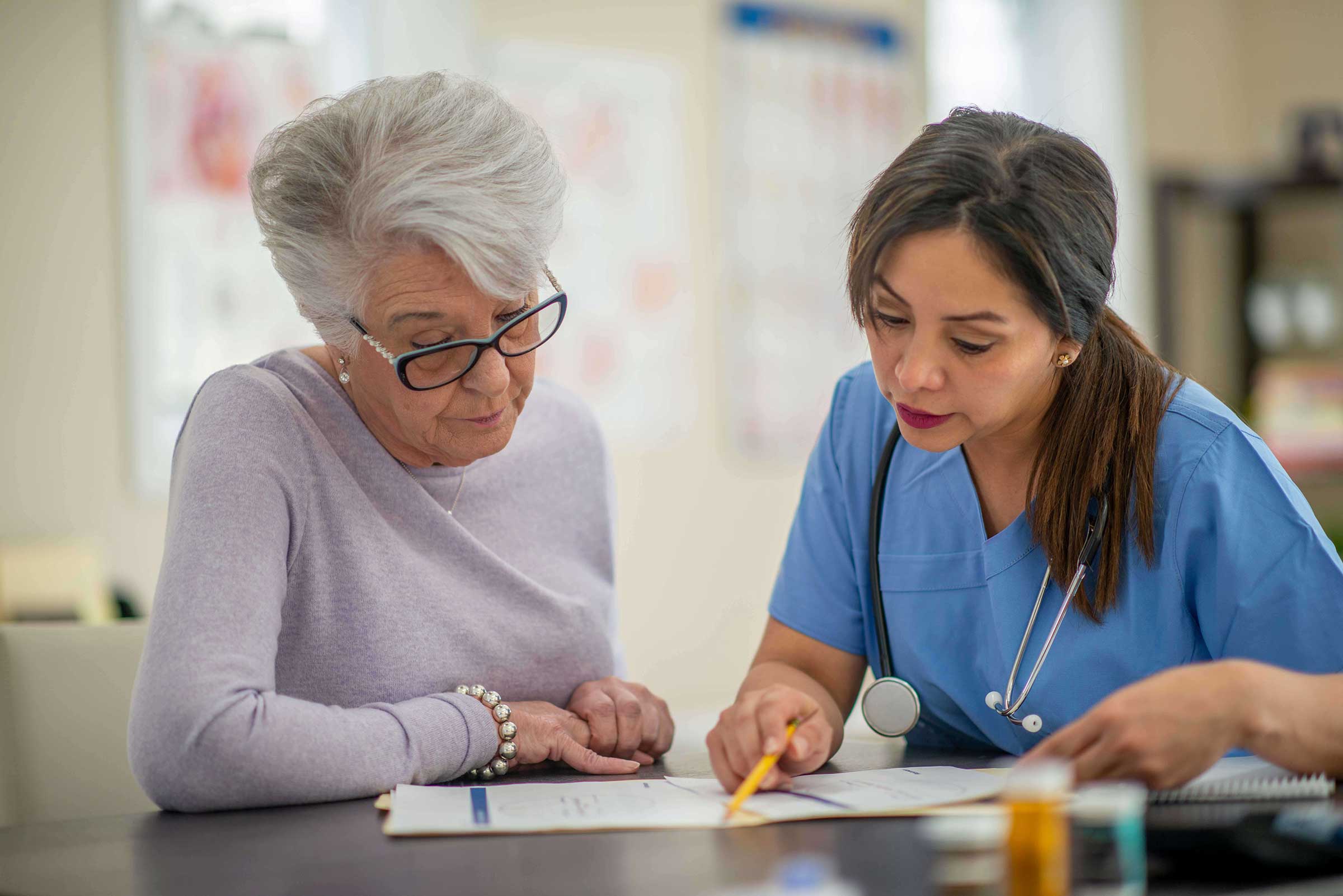 Nurse sat with patient looking over documents