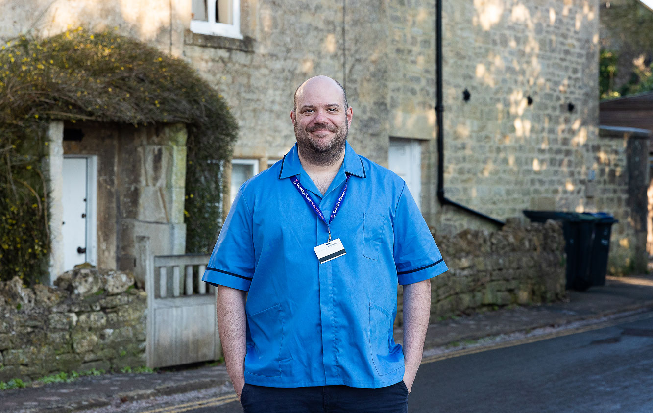 Man standing with his hands in his packets smiling at the camera